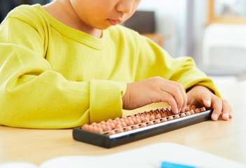 Dziewczynka z nauczycielem używająca kolorowego liczydła – LabStar Kids