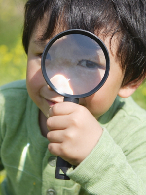 Chłopiec bawiący się lupą podczas zajęć edukacyjnych w LabStar Kids