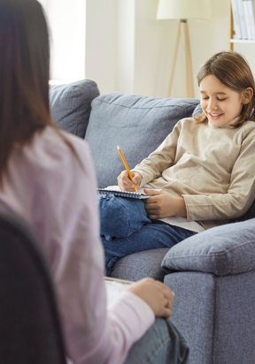 Chłopiec piszący w zeszycie podczas terapii u psychologa – LabStar Kids