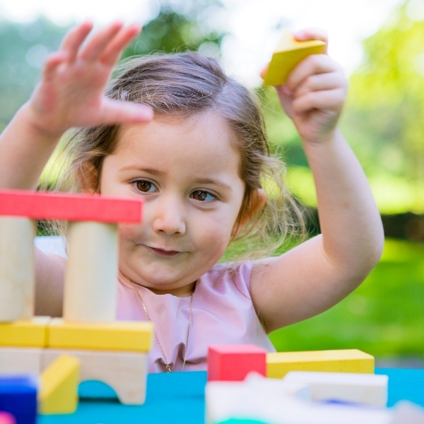 Dziewczynka budująca wieżę z kolorowych klocków – LabStar Kids