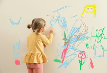 Dziewczynka rysująca kolorowe obrazki na ścianie – LabStar Kids