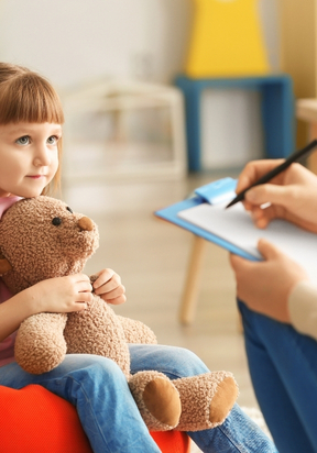 Dziewczynka trzymająca misia podczas spotkania z psychologiem – LabStar Kids